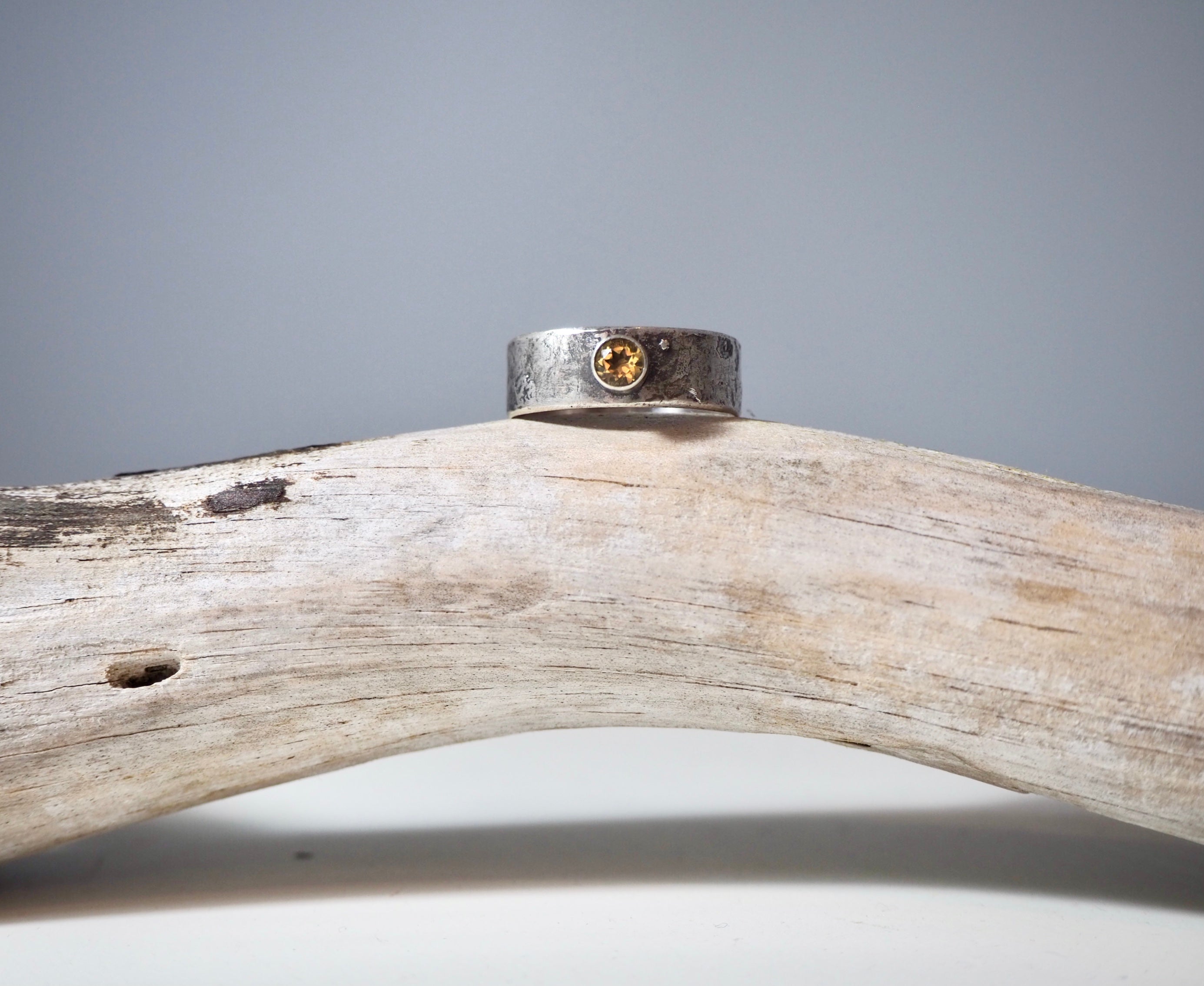 this is a handcrafted silver rustic ring with a clear brown stone